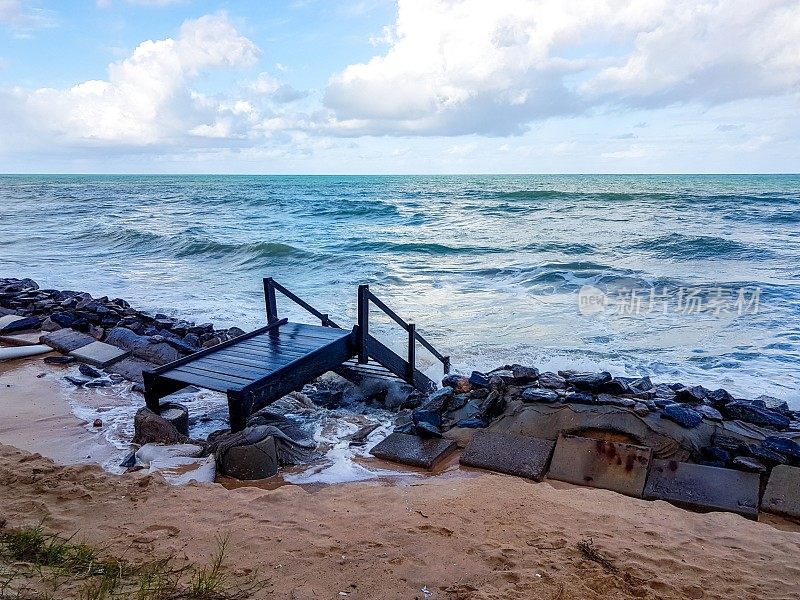 在巴西累西腓的Boa Viagem海滩，强大的蓝色海浪正向海浪块前进